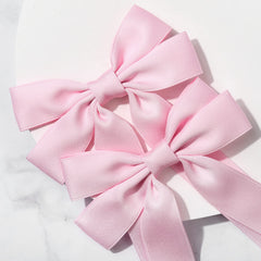 Lazo rosa de Aileam en coleta para un look rápido.