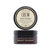 Polvo de impulso para cabello de American Crew en la mano, creando control y volumen ligero.