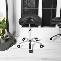 Taburete Antlu con asiento acolchado negro para mayor confort en sesiones largas.
