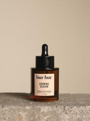 Bur Bur Aceite Crecimiento, botella en primer plano para cabello nutrido y suave
