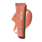 Balsamo Cay Skin Isle con brillo coral para labios, look luminoso.