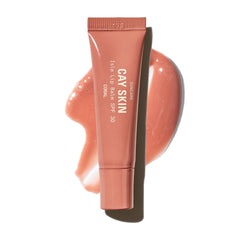 Balsamo Cay Skin Isle con brillo coral para labios, look luminoso.