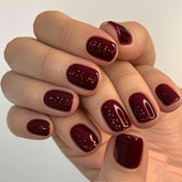 GLAMERMAID uñas cortas rojas burdeos con brillo para un look elegante.