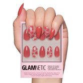 Glamnetic Love Me: uñas postizas en almendra con corazones rojos sobre base semitransparente.