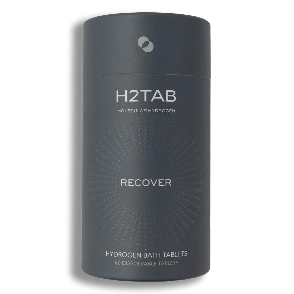 Tableta H2TAB de baño hidrógeno disolviéndose en agua para relajación muscular.