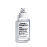 Frasco de Maison Margiela Replica Lazy Sunday Morning, fragancia fresca para el día.