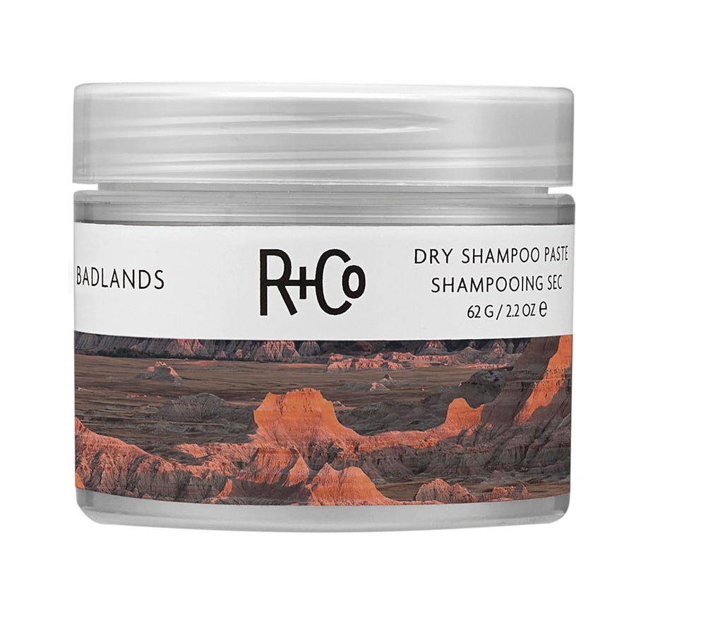 R+Co Badlands pasta champú en seco, bote compacto para retoques rápidos.