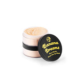 W7 Banana Dreams polvos sueltos en empaque doble, fijan maquillaje con acabado natural.