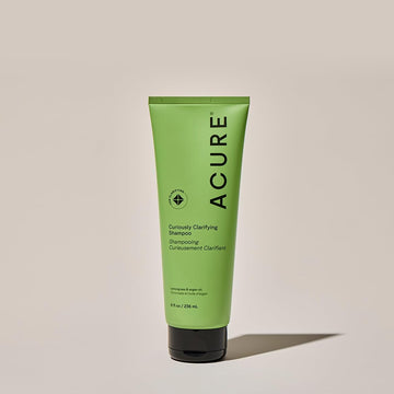 Gota de aceite de argán y Acure Curiously Clarifying Shampoo para nutrir y brillo.