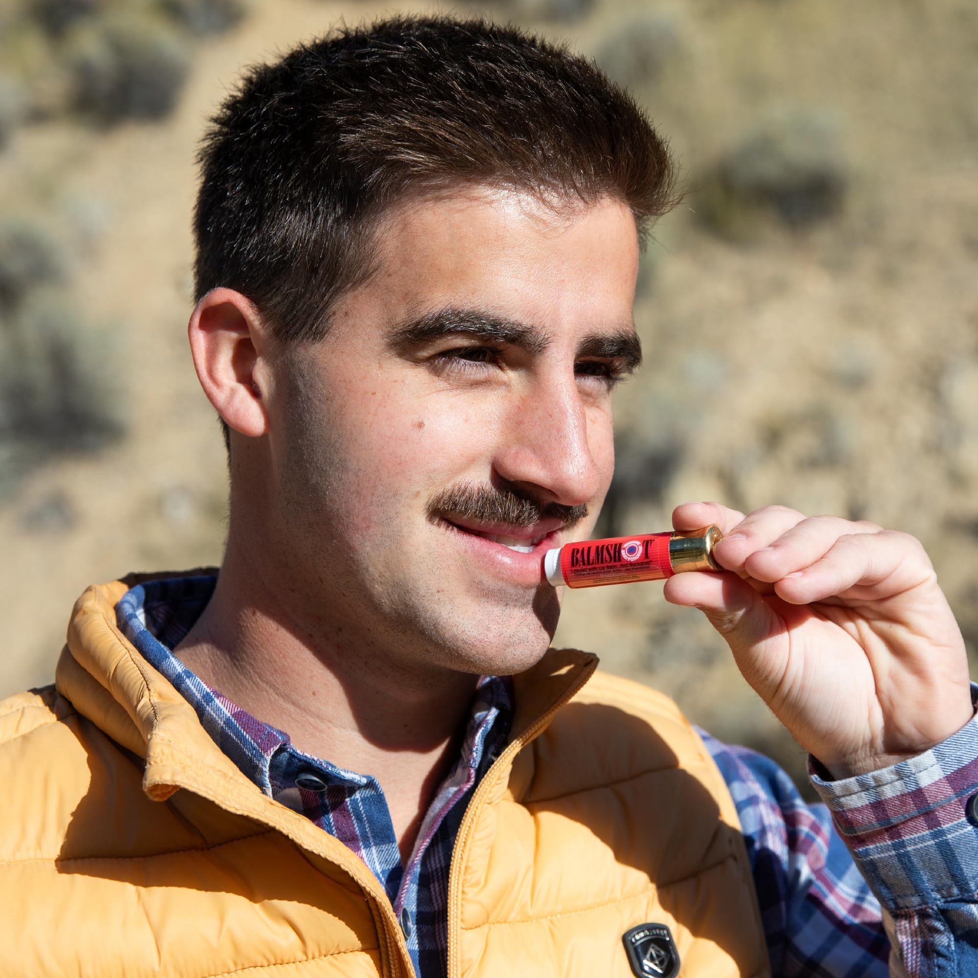 Balmshot lip balm in outdoor scene emphasizing portability and rugged use