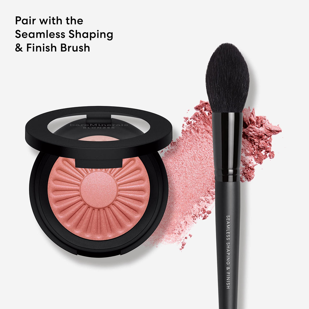 Pinceau fluffy sur les pommettes avec teinte rosée-bronze intensifiant le glow.