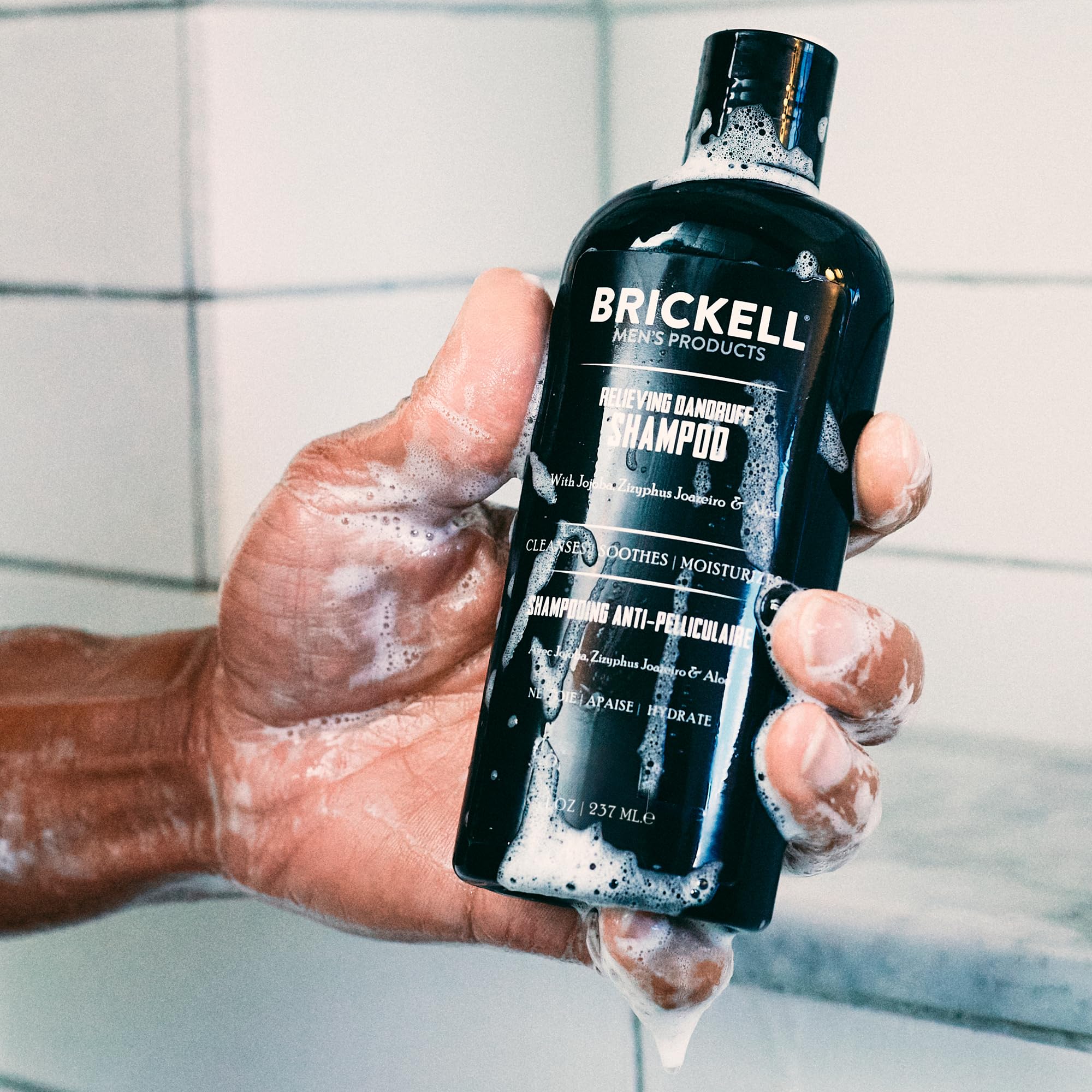 Aplicación manual del champú Brickell para cabello limpio y cómodo.