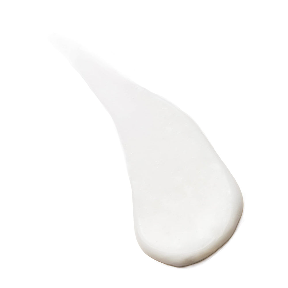Manos aplicando crema para proteger cabello durante el lavado.