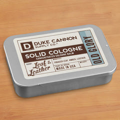 Duke Cannon Old Glory solid cologne being applied to the wrist for precise scent.