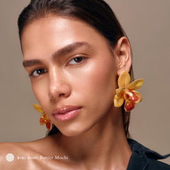 Applying Le Chouchou butter mochi balm to lips for smoothing