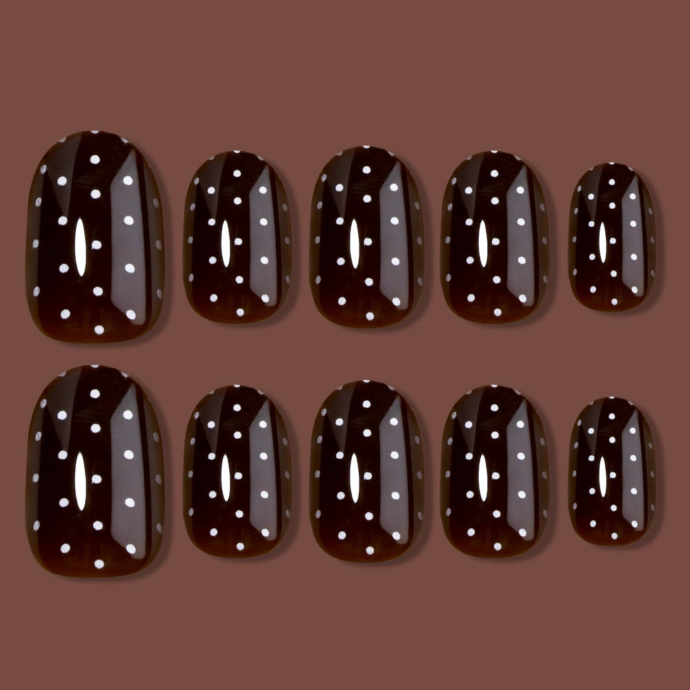 Detalle de brillo en uñas HOSAILY marrón oscuro con lunares blancos.