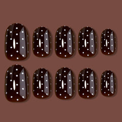 Detalle de brillo en uñas HOSAILY marrón oscuro con lunares blancos.