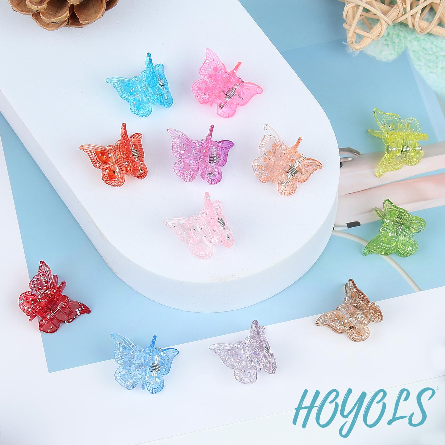 Hoyols clip mariposa brillantes en mano, muestra tamaño compacto y brillo duradero.