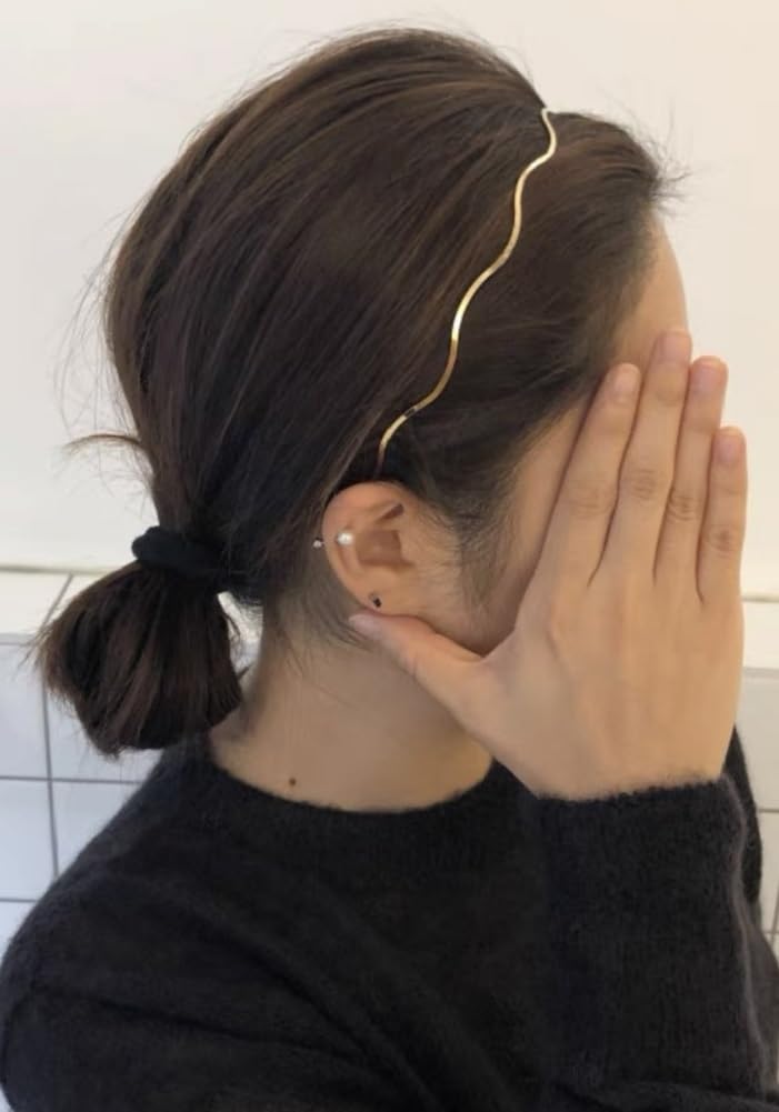 Diadema Huachi en dorado con diseño en onda, añade elegancia duradera a cualquier estilo.