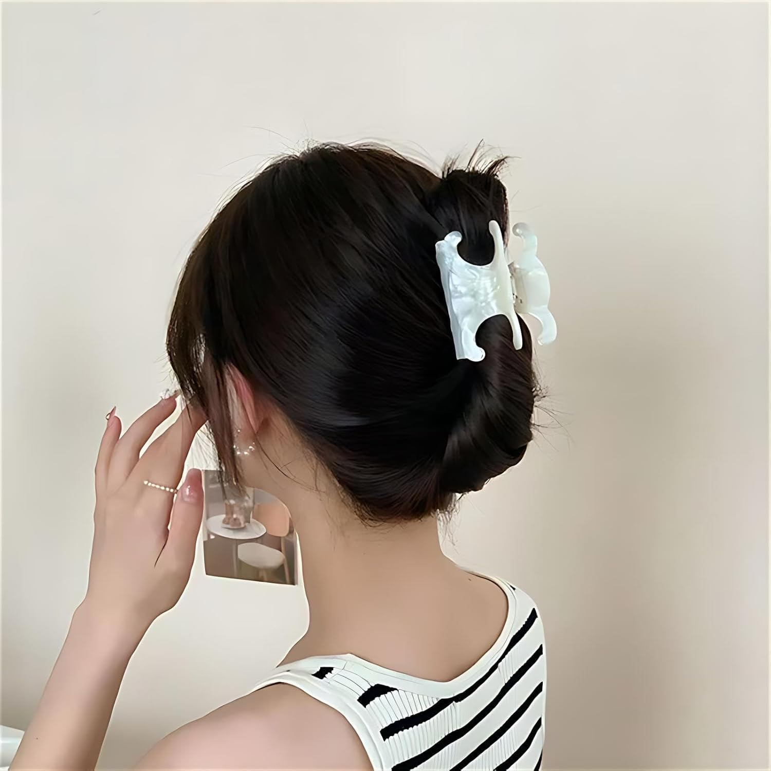 Clip acetato JITUIHOM diseño doble C en blanco marfil, sujetando peinados con delicadeza.