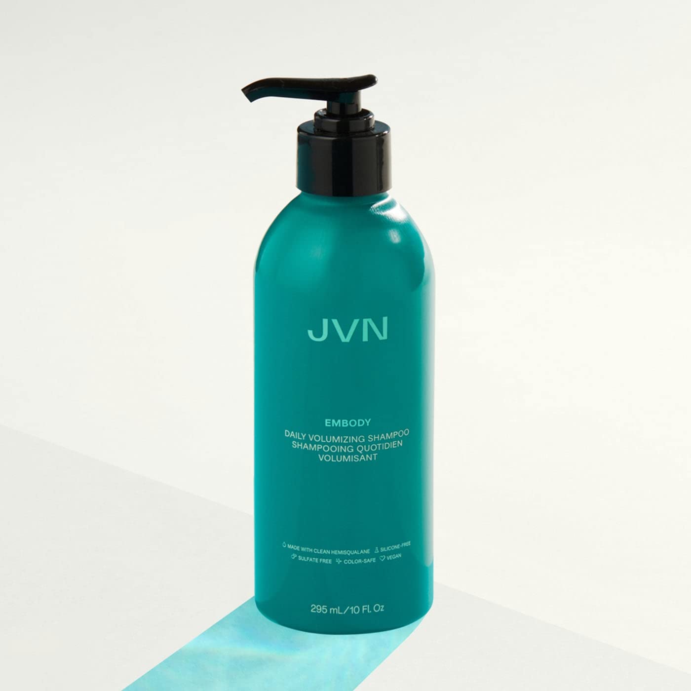 JVN Embody volumizing shampoo beside towels reveals natural shine and lift.