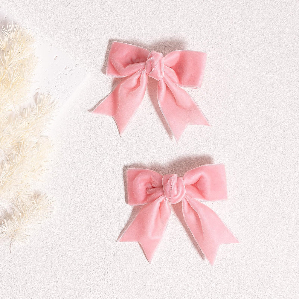 kchies dos broches de terciopelo rosado, sujetan el cabello con seguridad.