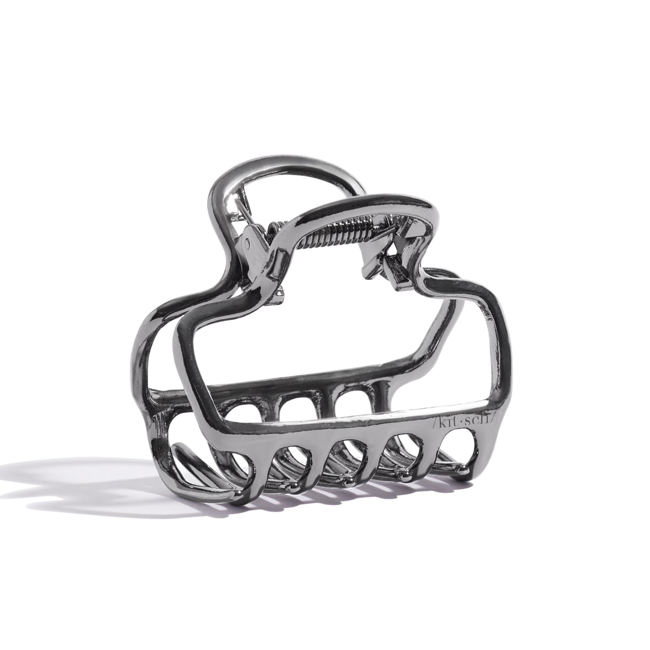 Kitsch clip de pelo hematita, silueta abierta, brillo discreto para estilos diarios.