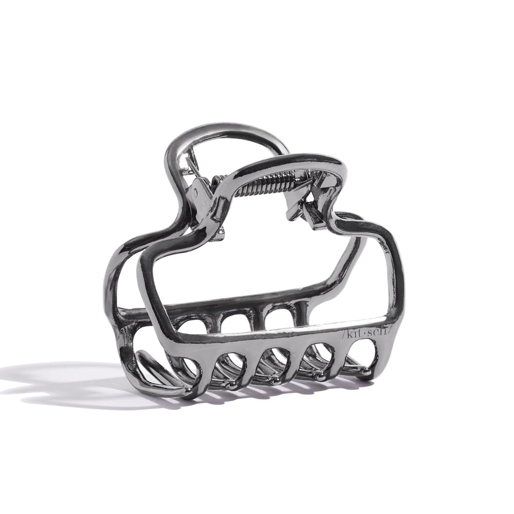 Kitsch clip de pelo hematita, silueta abierta, brillo discreto para estilos diarios.