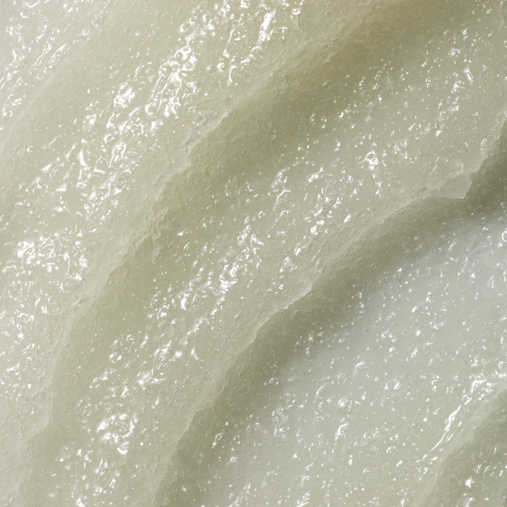 Textura de gránulos de Kristin Ess exfoliante que elimina acumulaciones sin resecar.