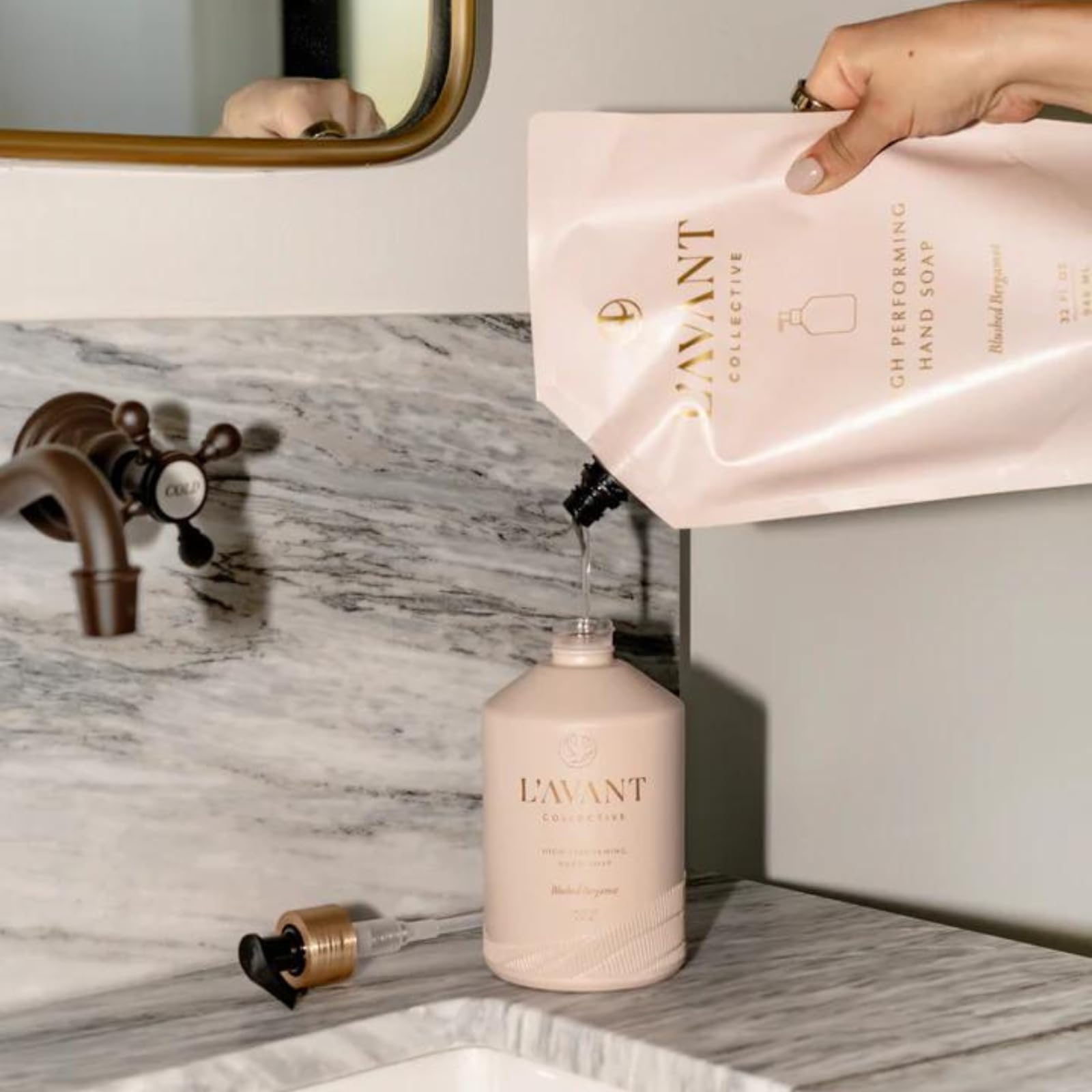Jabón de manos L'AVANT Collective, botella de vidrio rosa que destaca en cualquier lavabo.