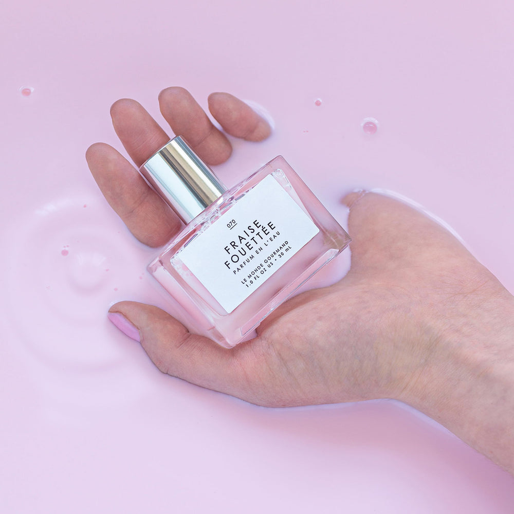 Frasco Le Monde Gourmand Fraise Fouettée con diseño elegante para sostener.
