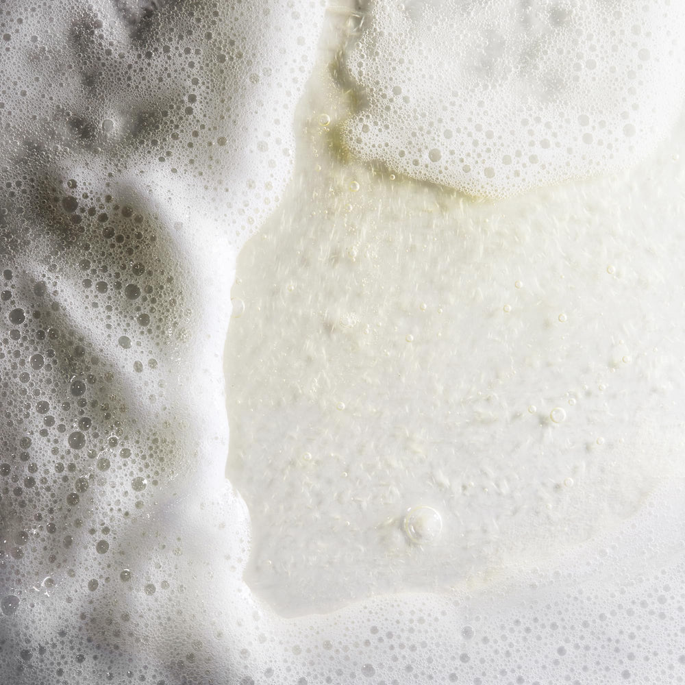 Application quotidienne du Nu-Derm Gentle Cleanser sur peau humide.