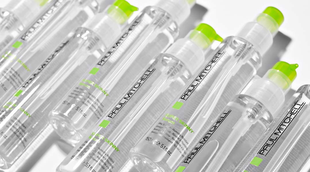 Paul Mitchell Suero Super Skinny en manos para aplicar uniforme y sellar la cutícula.