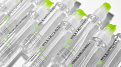 Paul Mitchell Suero Super Skinny en manos para aplicar uniforme y sellar la cutícula.