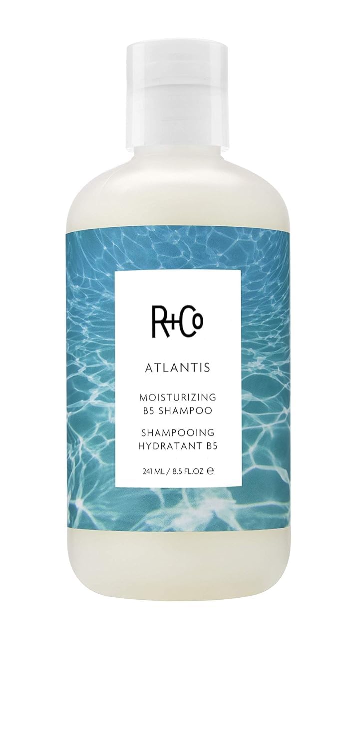 R+Co Atlantis Shampoing hydratant sur bouteille pour cheveux secs.
