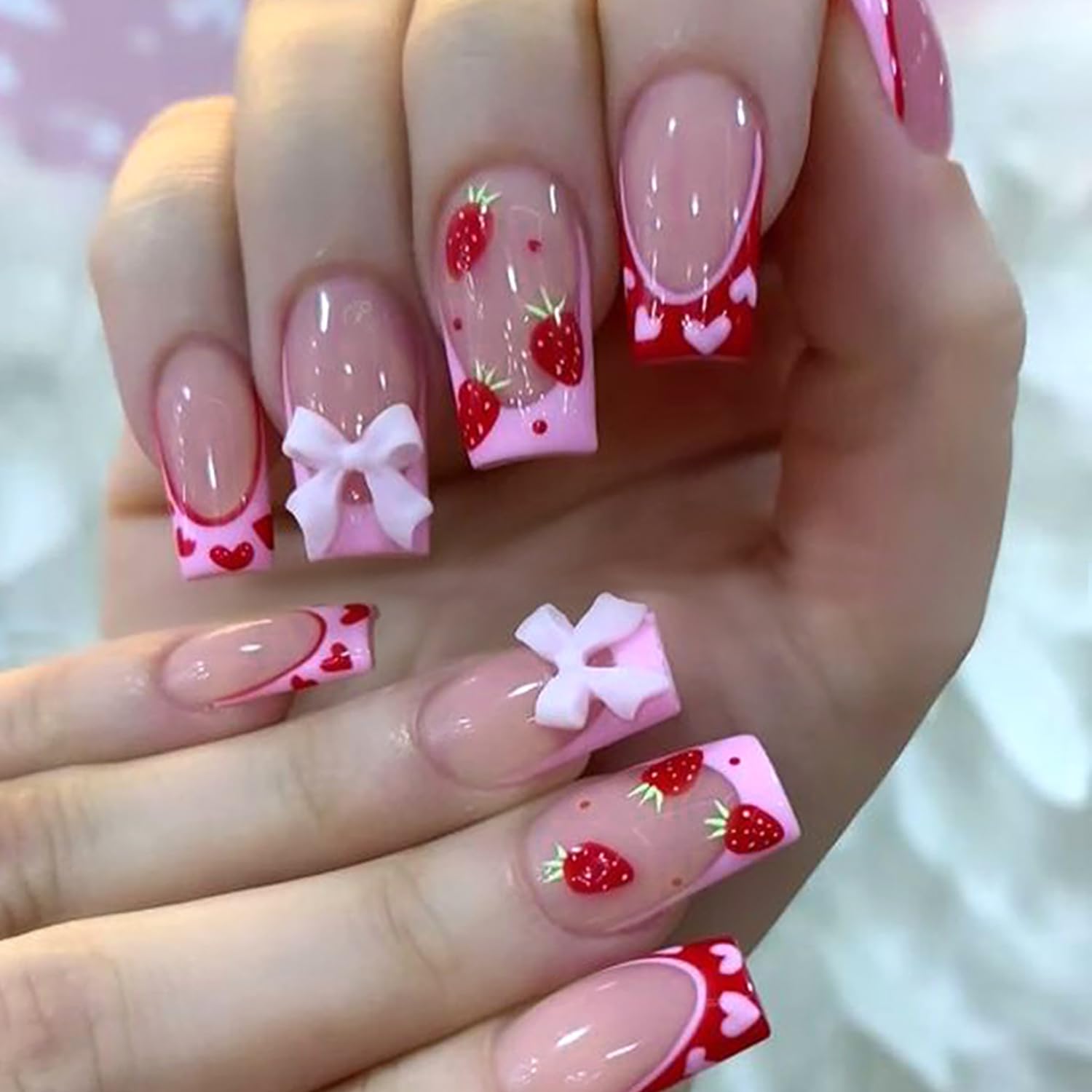 Uñas postizas de fresa con corazón rosa y lazo de TBRZTR para manicura rápida en casa.