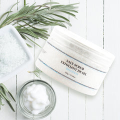 Manos aplicando Vivo Per Lei exfoliante corporal para piel suave.