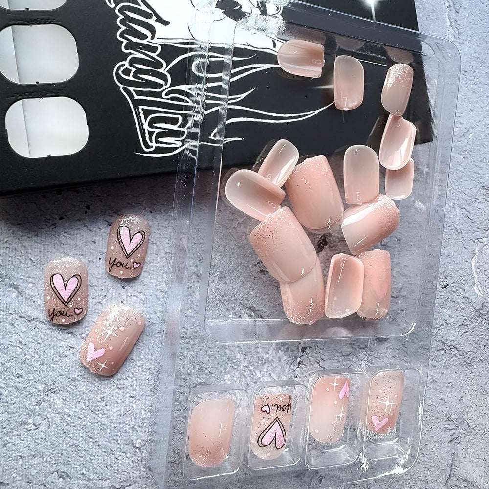 Uñas con corazones rosas en nude, look suave y romántico.