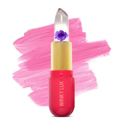 Bálsamo Winky Lux con flor rosa visible, tono personalizado y brillo suave.